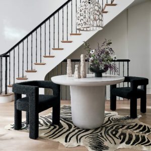 Black upholstered dining chairs around a white marble table.