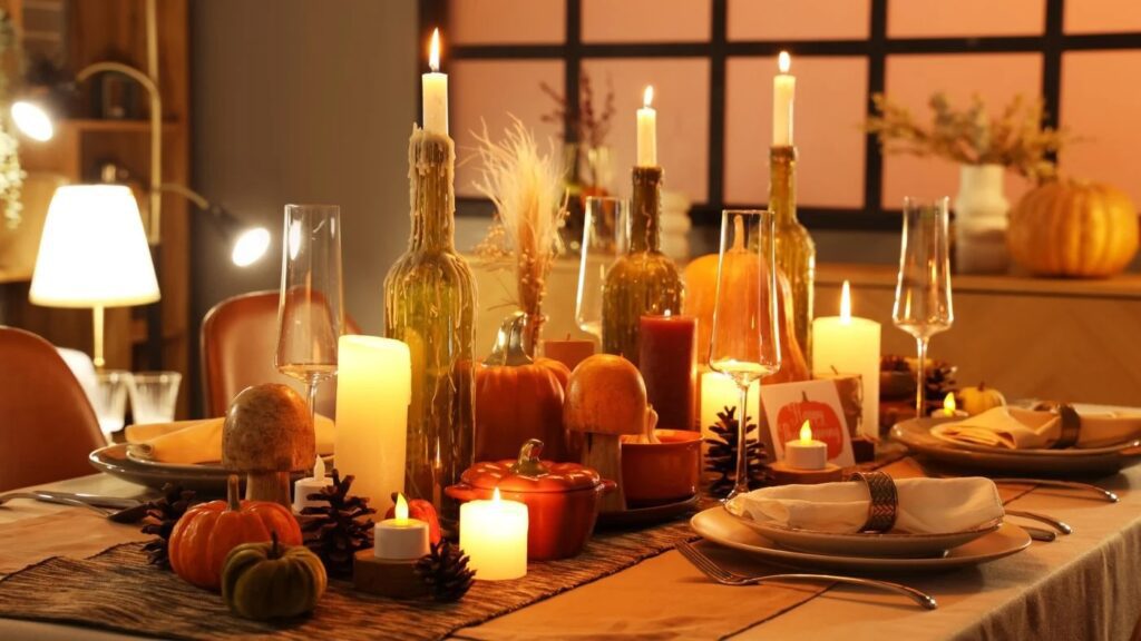 Thanksgiving table ideas guide says add lighting with candles, soft lamps, and sconces like this table with a variety of glowing lights.