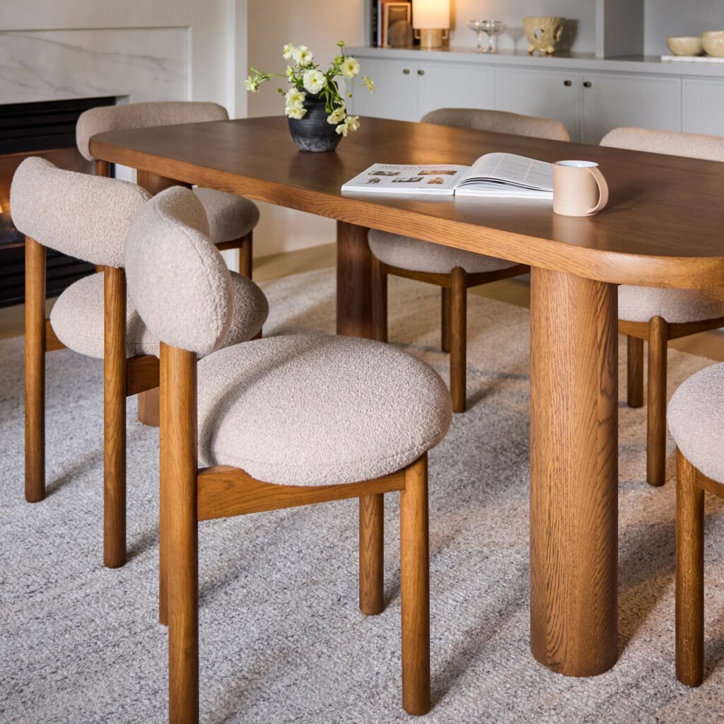 Wool boucle dining chairs around a wood table.