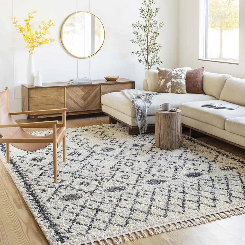 Charcoal and beige rug on a light wood floor in front of a sectional, media center, and chair.