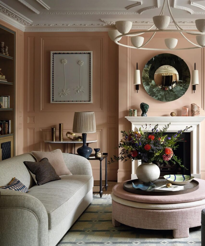Living room with light mocha walls, cream mantel fireplace, charcoal lamp, round marble mirror, and 