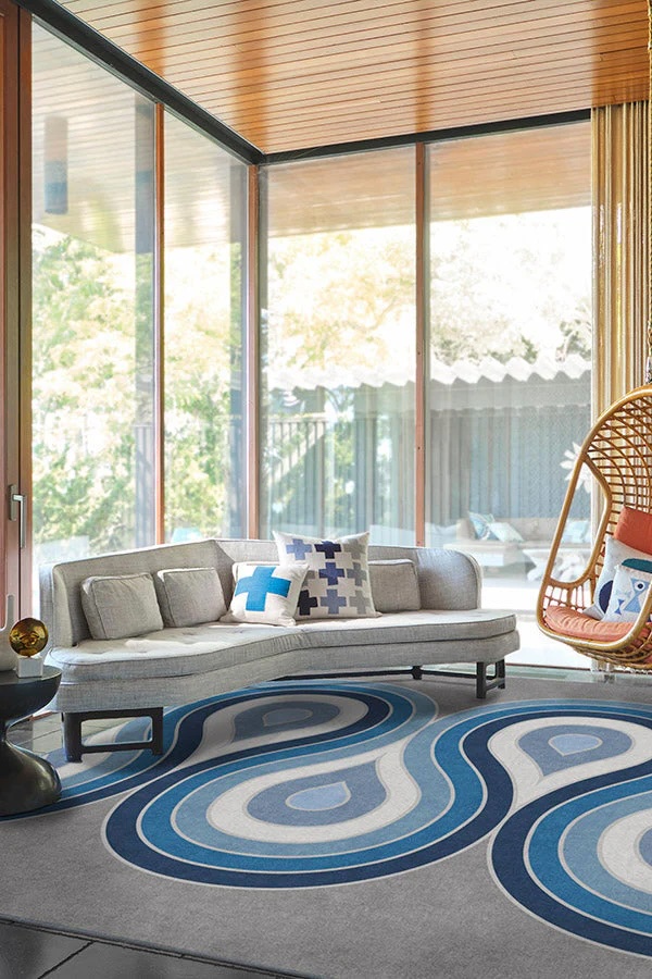 Modern living room centered around a bold area rug that establishes color and contrast.